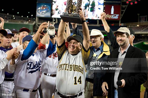 Coach Mike Doyle, D-Pa., holds the trophy after the democrats won the 48th Annual Roll Call Congressional Baseball Game held at Nationals Stadium,...