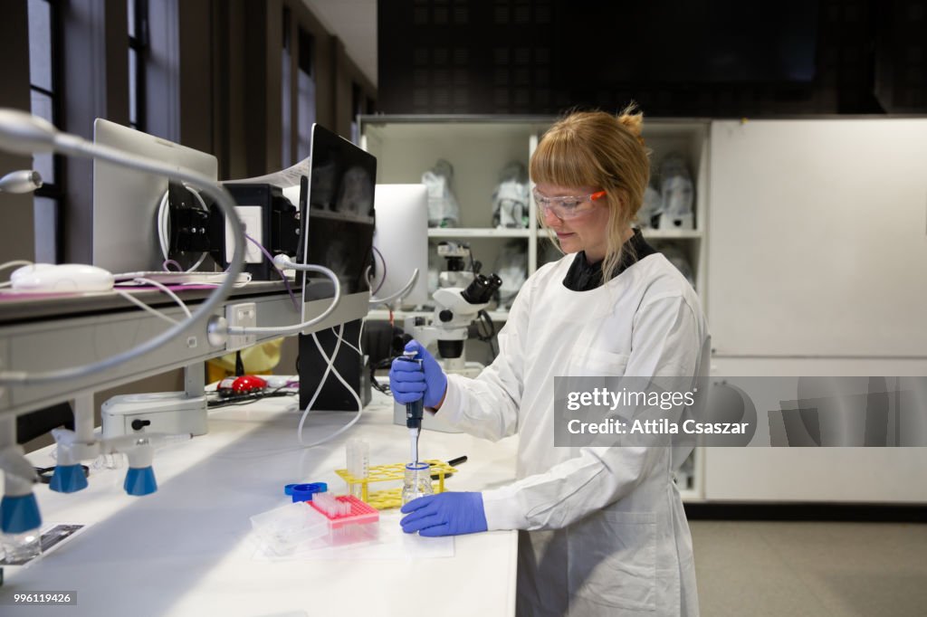 Female scientist pipetting in laboratory