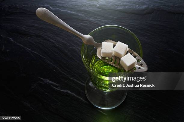 absinthe in pontarlier glass and spoon with sugar cubes - absinthe stock pictures, royalty-free photos & images