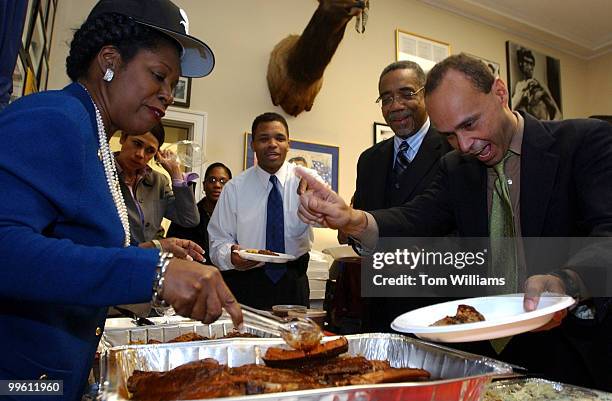 Rep. Shelia Jackson Lee, D-Texas, serves Texas barbecue from Houston's Landry's Restaurant Inc., to members of Chicago delegation from left, Reps....