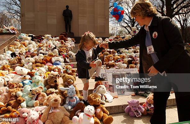Abbey Pinkerton of Georgia, is helped by her mother, Jennifer, out of over 200 Teddy bears that represent children waitng for adoption, that are...