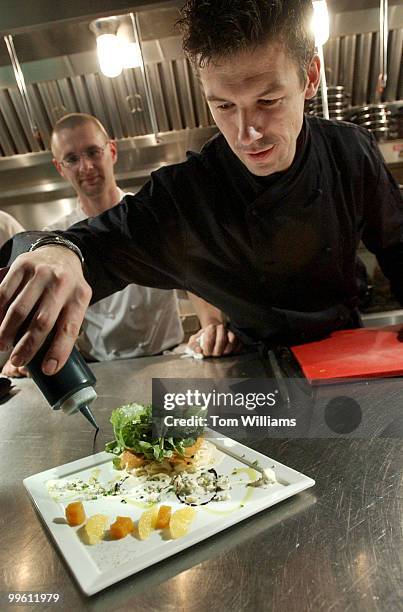 Chef Bart Vandaele prepares garnishes a dish at Belga Cafe on 8th St., SE.