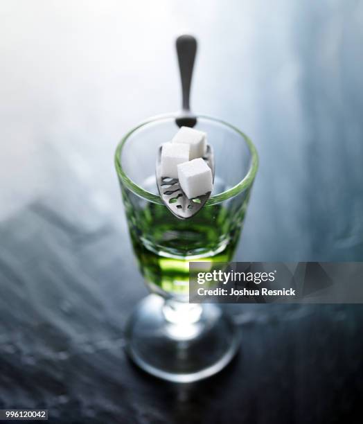 absinthe in pontarlier glass with spoon and sugar cubes - pontarlier stock pictures, royalty-free photos & images