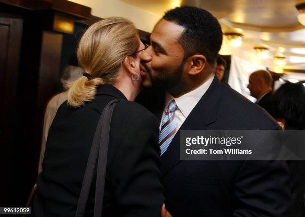 Jerome Bettis of the Pittsburgh Steelers, kisses Kellie Johnson of GlaxoSmithKline, after a news conference held by the U.S. Surgeon General and the...