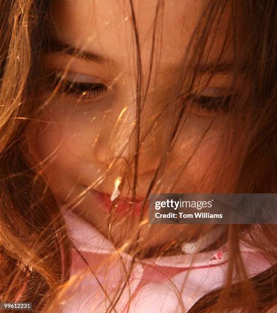 Veronica Gutierrez, 2 1/2, of Reston, stares at a fallen cherry blossoms petal that landed in her hair, in Upper Senate Park, Wednesday.