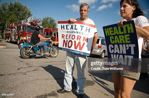 Anthony LaRusso of Scranton, and Dorene Schutz of Wilkes-Barre, hold pro health care reform signs outside of a town hall meeting conducted by Rep....
