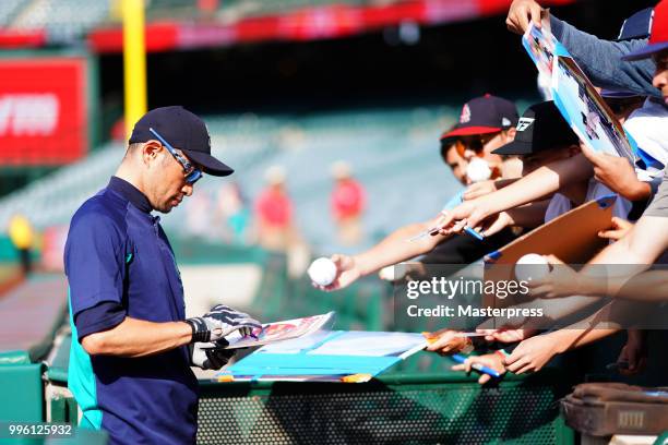 Ichiro Suzuki of the Seattle Mariners signs autographs for fans during the MLB game against the Los Angeles Angels at Angel Stadium on July 10, 2018...