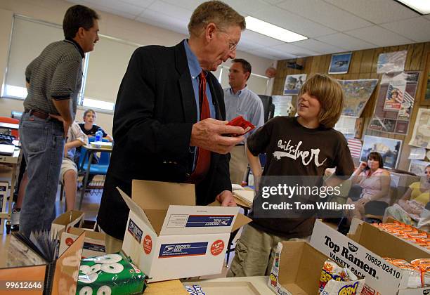 Sen. Conrad Burns, R-Mont., talks with 8th grader Shane Page as they make care packages for soldiers in Iraq at Will James Middle School in Billings,...