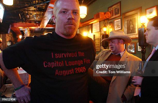 Bartender from Capitol Lounge, dons a tee shirt making fun of the fire that shut the bar down in August, on the first day the bar was open.