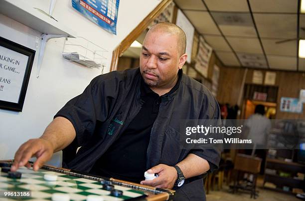 Robbie Mason, co-owner of Mason's Barber Shop, plays checkers during a slow day in the shop, April 5, 2010.