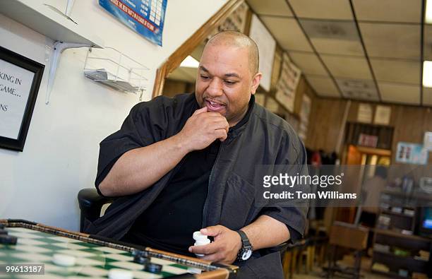 Robbie Mason, co-owner of Mason's Barber Shop, plays checkers during a slow day in the shop, April 5, 2010.