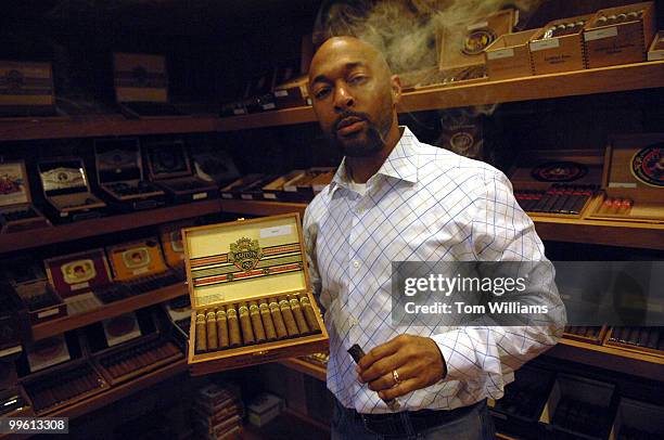 Ronald Wright, owner of Capitol Hill Premium Cigars & Tobacco on Florida Avenue, NE., poses for a photo with a box of Ashton cigars.