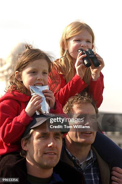 Emma Jenks left, and Lyla Ward sit atop the shoulders of their fathers Brett Jenks,left, and Stephen Ward, as they watch approaching elephants from...