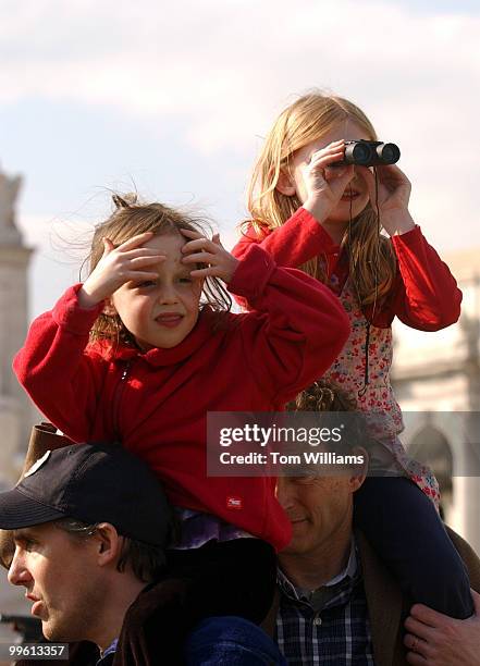 Emma Jenks left, and Lyla Ward sit atop the shoulders of their fathers Brett Jenks,left, and Stephen Ward, as they watch approaching elephants from...