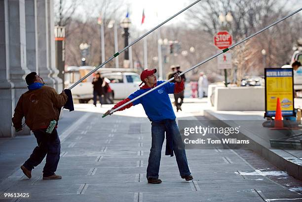 Workers use long poles attached to squeegees to clean the windows of the Bike Station, outside of Union Station, Mar. 8, 2010.