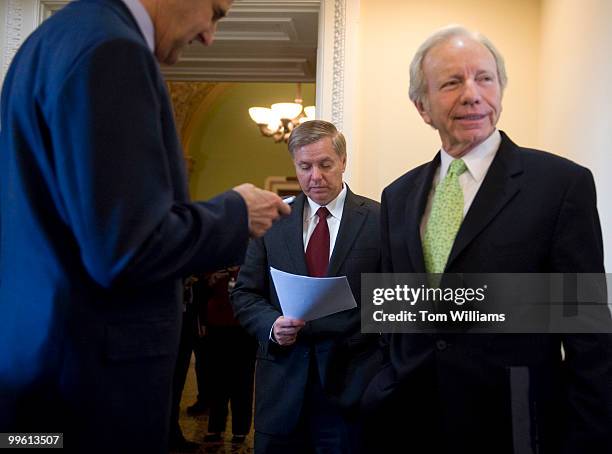 From left, Sens. John Kerry, D-Mass., Lindsey Graham, R-S.C., and Joe Lieberman, I-Conn., prepare for a news conference on climate change, Dec. 10,...