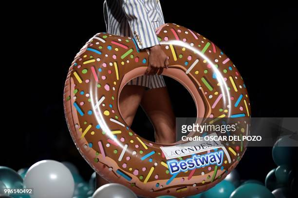 Model holds a rubber ring while displaying an outfit of Spanish designer La Condesa Spring/Summer 2019 collection during the Madrid's Mercedes Benz...