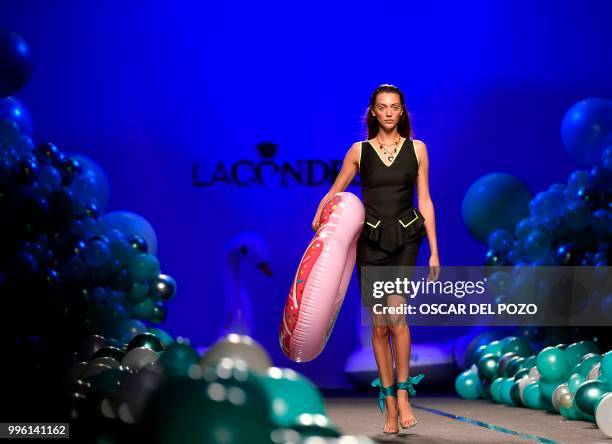 Model holds a rubber ring while displaying an outfit of Spanish designer La Condesa Spring/Summer 2019 collection during the Madrid's Mercedes Benz...