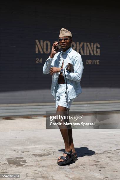 Guest is seen on the street attending Men's New York Fashion Week wearing blue shirt and shorts with cadet hat on July 10, 2018 in New York City.