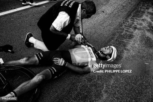 Race medic check France's Axel Domont shoulder after he was caught in a massive pack fall in the last kilometers of the fourth stage of the 105th...