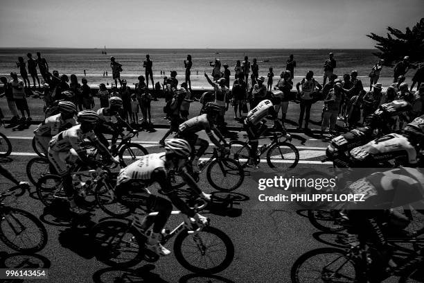 Spectators cheer as the pack rides along the seafront of La Baule during the fourth stage of the 105th edition of the Tour de France cycling race...