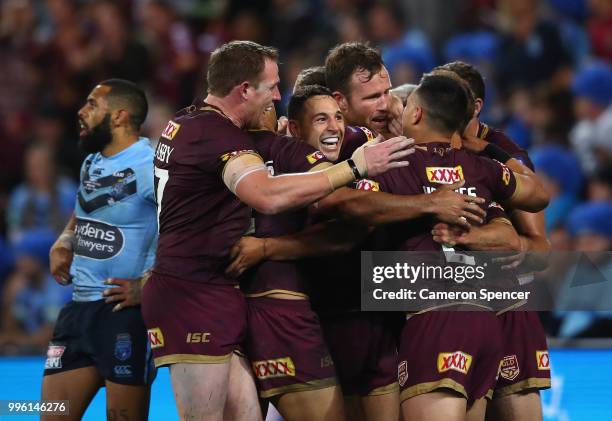 Daly Cherry-Evans of Queensland is congratulated by team mates after scoring a try during game three of the State of Origin series between the...