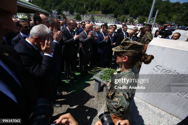 People place flowers and pray for victims following the burial ceremony of newly identified 35 victims during the 23rd anniversary of the 1995...