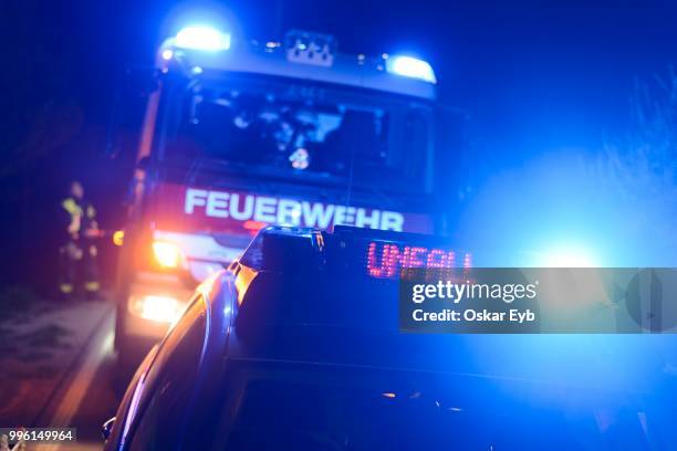 fire engine and police car with flashing blue lights and the led display --unfall--, german for --accident--, at a crash site, weil im schoenbuch, baden-wuerttemberg, germany - unfall bildbanksfoton och bilder