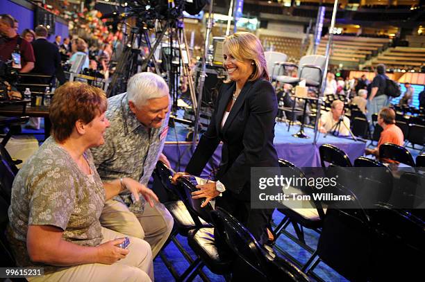 Katie Couric of CBS News talks with Mike and Cheryl Fisher of Indiana in the Pepsi Center before the start of the Democratic National Convention,...