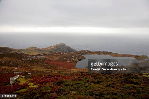 lake at slieve league or sliabh liag in front of the north atlantic ocean, county donegal, ireland - slieve league donegal stock pictures, royalty-free photos & images
