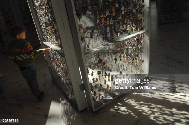 Alexander Craig of Houston, looks at a memorial to fallen soldiers in Iraq and Afghanistan, on display in the Russell Rotunda. The figures in the...