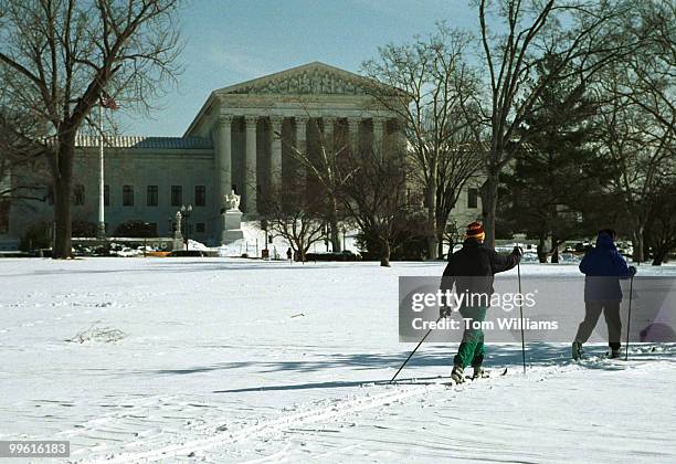 Schools employee Sarah Burke and Brad Snell cross country ski across the East Front on a snow day, Wednesday. Tom Williams