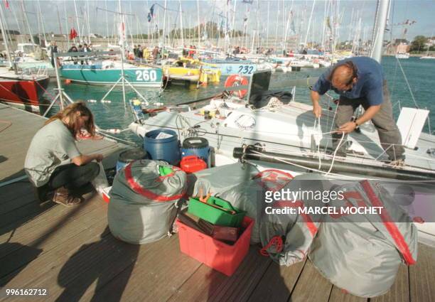 Des équipiers du monocoque de 6,50 mètres "Elvox", skippé par l'italien Ettore Dottori, ravitaillent le voilier, le 24 septembre 1999 sur le port de...