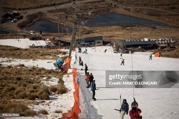 Ski enthusiasts reach the top of the main 1km slope at the Lesotho Kingdom ski resort Afriski, in the Maluti Mountains, on July 11, 2018. - Nestled...