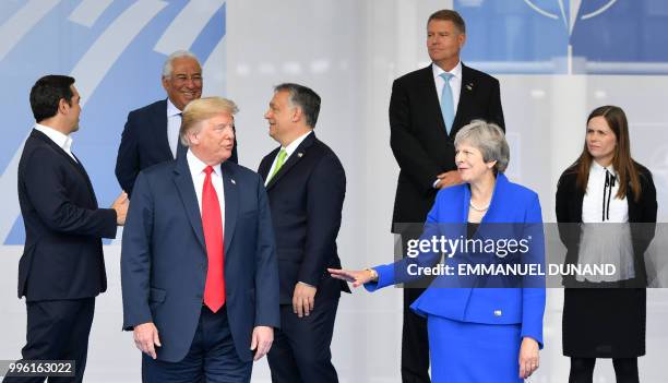 President Donald Trump gestures as he poses alongside Britain's Prime Minister Theresa May and Iceland's Prime Minister Katrín Jakobsdóttir during...