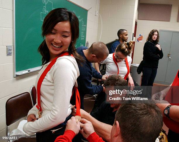 Eunie Kim, from the office of Rep. Tom Lantos, gets some help putting on her firefighters gear from staff at the Maryland Fire Rescue Institute...