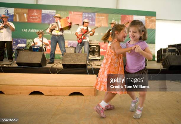 Hayley Coleman, left, and Brooke Seligman, both 4, of Gaithersburg, dance to Las Estrellas del Vallenato in the Las AmTricas section of the...
