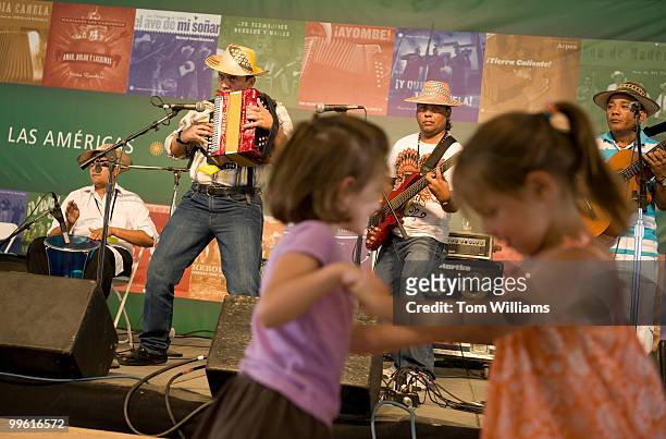 Las Estrellas del Vallenato play as Hayley Coleman, right, and Brooke Seligman, both 4, of Gaithersburg, dance in the Las AmTricas section of the...