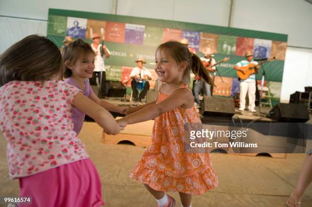 From left, Ivy Seligman, Brooke Seligman, and Hayley Coleman, all 4 years old, of Gaithersburg, dance to Las Estrellas del Vallenato in the Las...