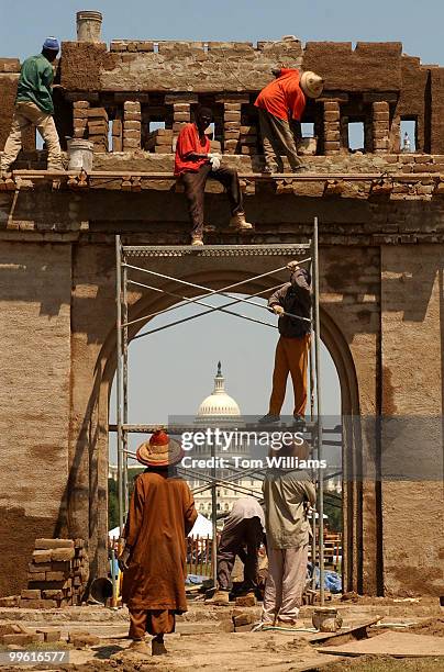 Masons from Mali, a country in West Africa, assemble the replica of a gate that is an example of an entrance to a town from ancient times, for the...