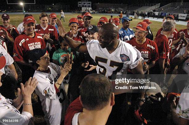 Former Redskin Ken Harvey celebrates with Win-Ling Chestnut, widow of Officer J.J. Chestnut, killed in 1998, at the end of the 3rd Biennial Longest...