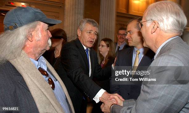 Rep. Chris Shays, R-Conn., right, shakes hands with Sen. Chuck Hagel, R-Neb., on the first day of the 109th Congress. Musician David Crosby looks on.