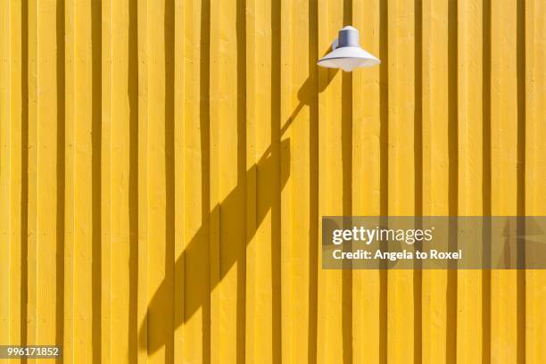 lamp on a yellow beach hut casting a long shadow, ile d'oleron, charente maritime, poitou-charentes, france - poitou charentes imagens e fotografias de stock