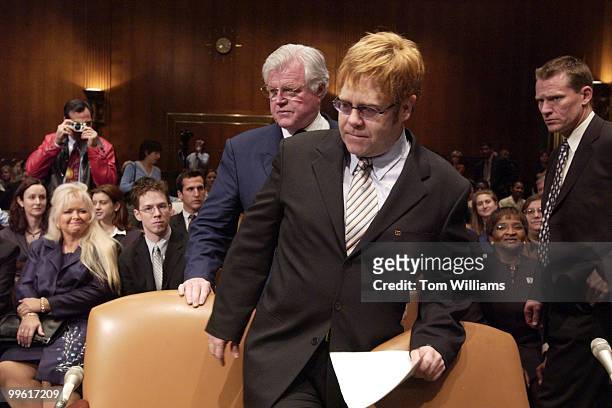 Musician Elton John is seated by Sen. Ted Kennedy, D-Mass., before testifying on the world wide AIDS epidemic in front of the Senate Health,...