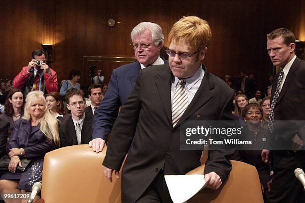 Musician Elton John is seated by Sen. Ted Kennedy, D-Mass., before testifying on the world wide AIDS epidemic in front of the Senate Health,...