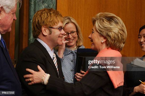 Musician Elton John greets Sen. Hillary Clinton, D-N.Y., right, before testifying on the world wide AIDS epidemic in front of the Senate Health,...