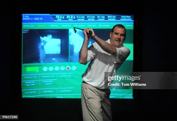Bryan Huus, president, Capitol Hill Golf LLC, critiques the reporter's technique at their indoor simulator facility on the Hill, May 11, 2008.