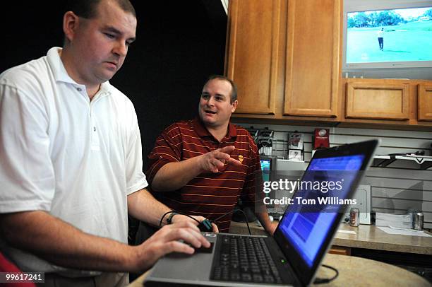 Bryan Huus, left, president, Capitol Hill Golf LLC, and Bob Shelton, vice president, goes over the reporters statics from a golf lesson at their...
