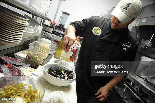 Teddy Folkman, executive chef/owner of Granville Moore's, prepares a serving of Moules Fromage Bleu, which are mussels with bacon and bleu cheese, at...