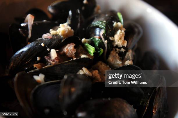 Teddy Folkman, executive chef/owner of Granville Moore's, displays a serving of Moules Fromage Bleu, which are mussels with bacon and bleu cheese, at...